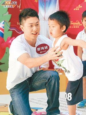 李小鵬教小朋友玩體操，十分投入。