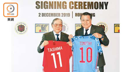 香港足總會長霍震霆（左）與日本足協會長田嶋幸三交換球衣紀念。