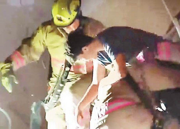 消防員把一名男孩救出。