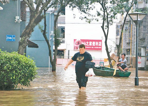 柳州市的市民被迫涉水而行。（中新社圖片）