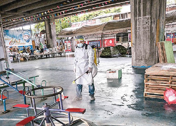 曼谷有義工向兒童遊樂設施噴灑消毒液。（Getty Images圖片）