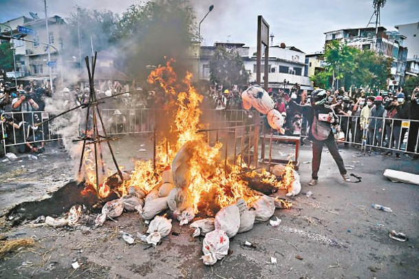 示威者焚燒塗上紅色油漆的假屍袋。
