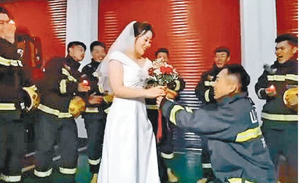 男消防員捧花向女友求婚。