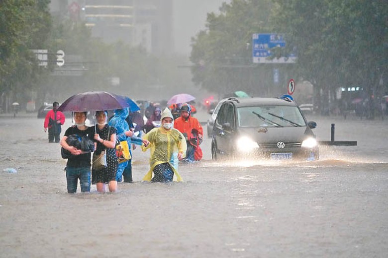 民眾在暴雨中涉水而行。