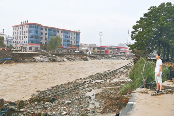 在鞏義市米河鎮，洪水退卻後河道旁滿布垃圾。（中新社圖片）