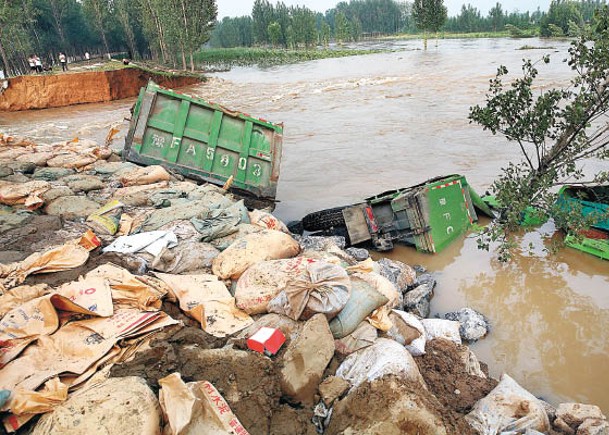 多輛汽車堵塞河南省鶴壁市衞河堤壩缺口處。