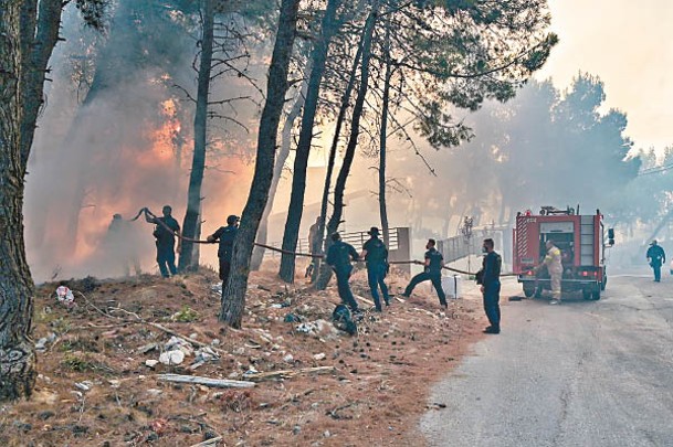 雅典警員協助消防員灌救。（Getty Images圖片）