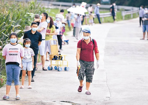 湖南：湖南省張家界市工作人員在檢測點排隊現場消毒。