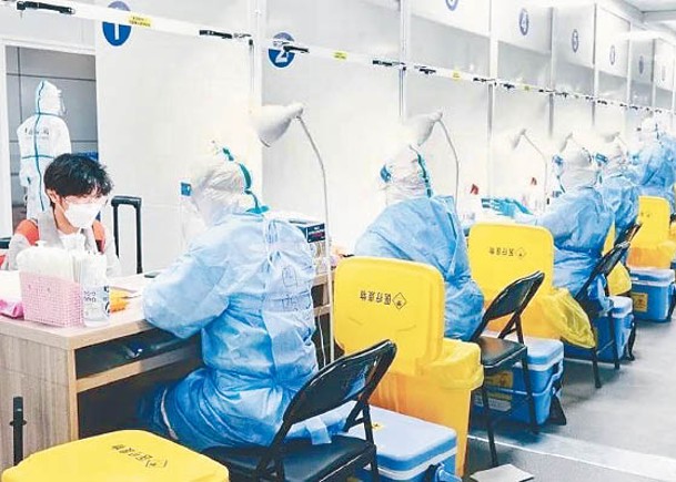 上海浦東機場的工作人員，為入境旅客進行檢測。