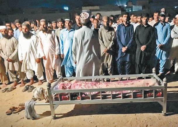 一批家屬替炸彈襲擊事件中的死者舉行葬禮，眾人神情哀傷。