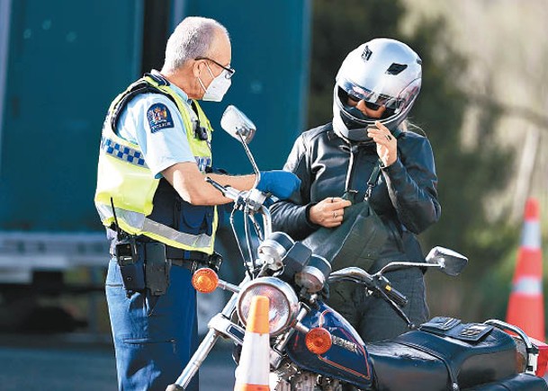 奧克蘭封城，警員檢查電單車司機的證明文件。（Getty Images圖片）