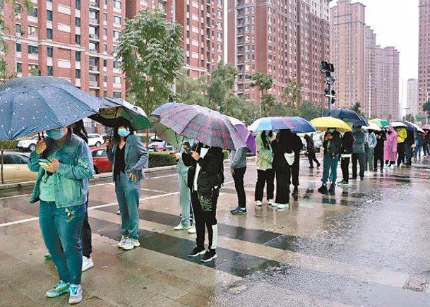 哈爾濱市居民排隊等待接受核酸檢測。（中新社圖片）