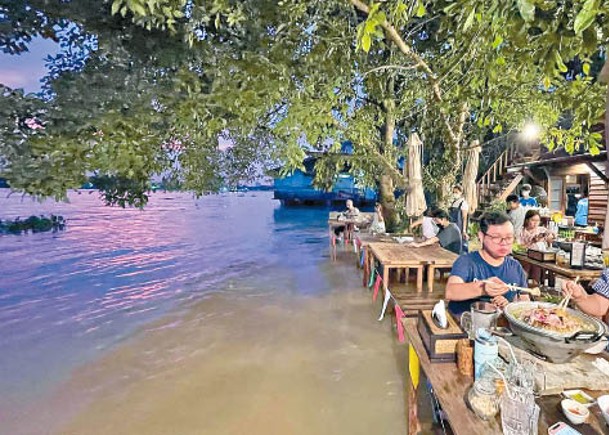 餐廳顧客坐在水中用餐。
