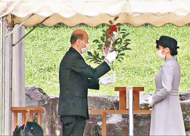 宮內廳官員協助真子公主（右）獻上祭品。