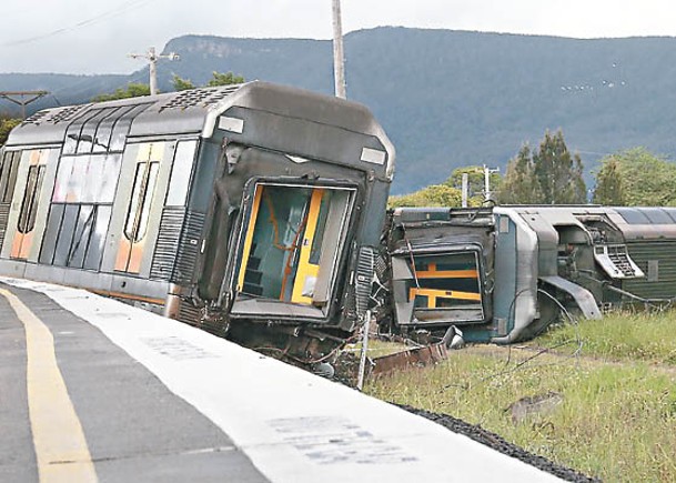 列車與汽車相撞，首卡車廂脫軌翻側。