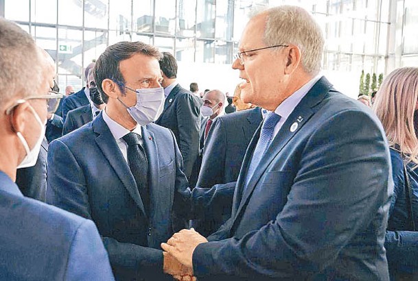 馬克龍（左）與莫里森（右）出席羅馬G20峰會時會面握手。