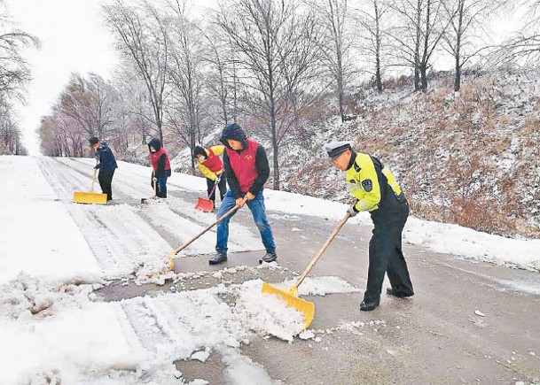 警員協助清理路面的積雪。