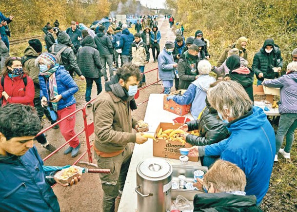 在法國，有慈善組織向難民派食物。