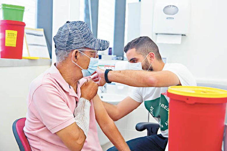 以色列：一名市民接種第三針新冠疫苗。