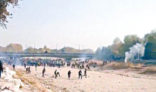 示威者走進乾枯的河道示威。
