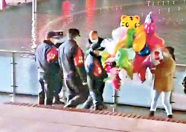 多名城管包圍小販，並搶走氣球。