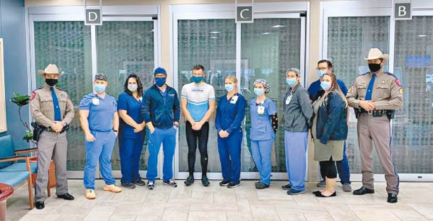 奎格利（左五）到醫院與一眾醫護人員合照。