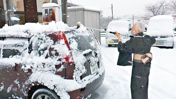 日本東北居民清理積雪。