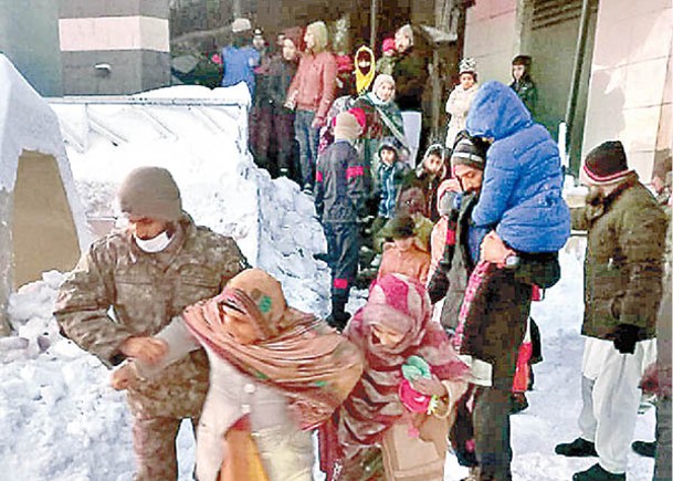 救援人員協助被積雪圍困的遊客離開。