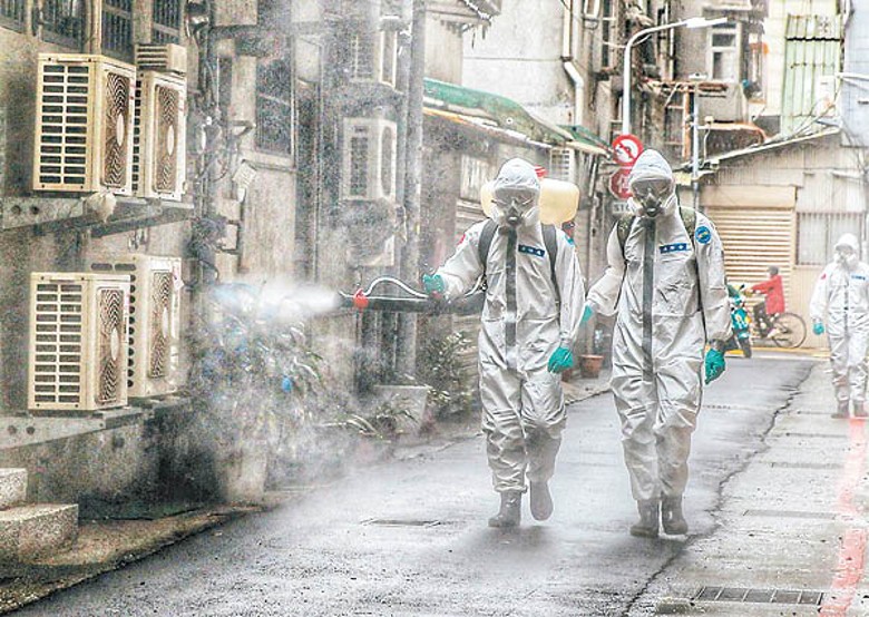 台灣有穿上保護衣的防疫人員在街頭消毒。