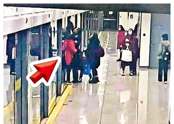 女乘客（箭嘴示）被月台幕門夾住，其後被列車捲走身亡。