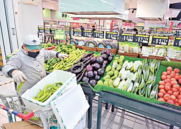 呼和浩特市超市工作人員為蔬菜攤位補貨。