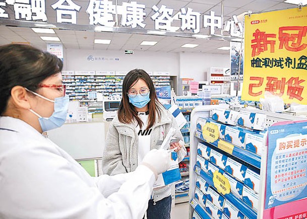 天津市居民在藥房向藥劑師查詢新冠檢測試劑盒。（中新社圖片）