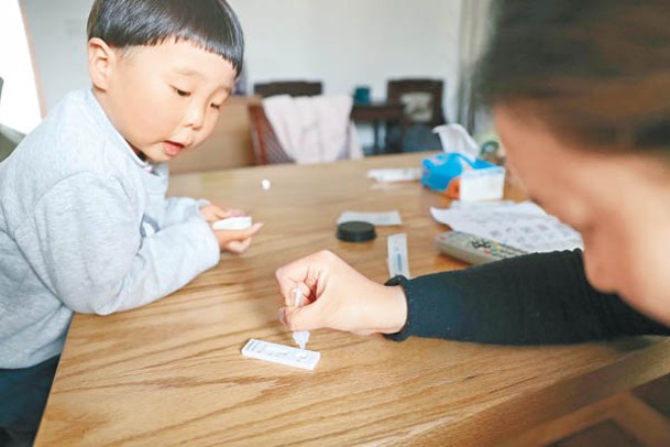 上海一名市民在家進行抗原檢測。（中新社圖片）