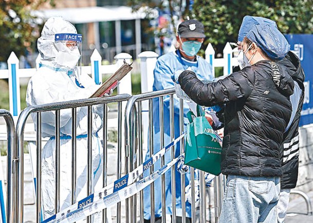 工作人員幫助封閉管理的患者到上海市同仁醫院開藥。（中新社圖片）