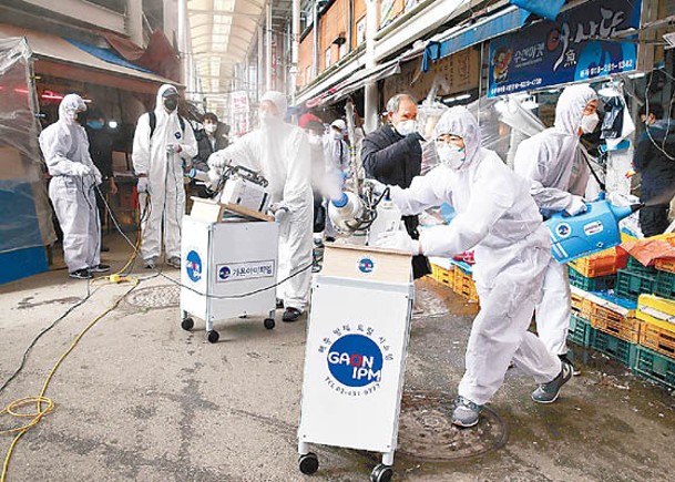 防疫人員在首爾街頭消毒。（Getty Images圖片）