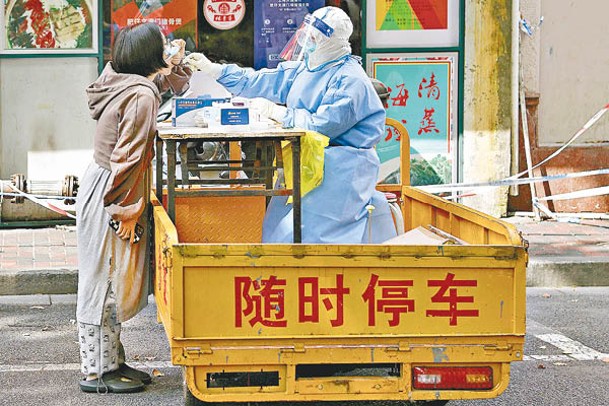 醫護人員在上海市靜安區為居民進行核酸檢測採樣。