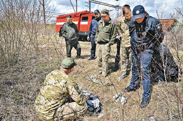 烏克蘭軍人及警員檢視導彈殘骸。