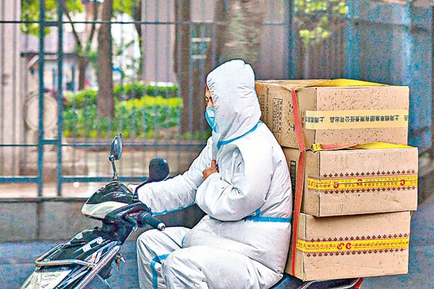 上海市一名快遞員冒雨配送物資。<br>（中新社圖片）