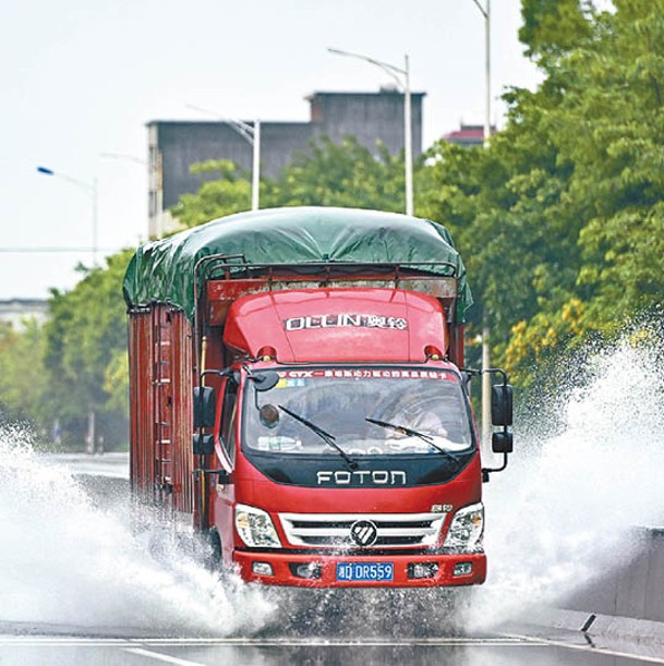 廣州：貨車涉水而行。