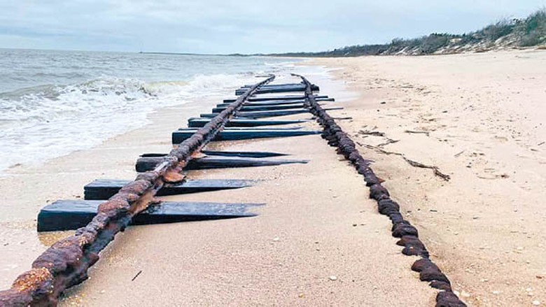 沙灘退潮時露出生銹鐵軌。