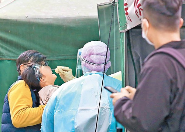 台灣家長帶孩子到快篩站做篩檢。