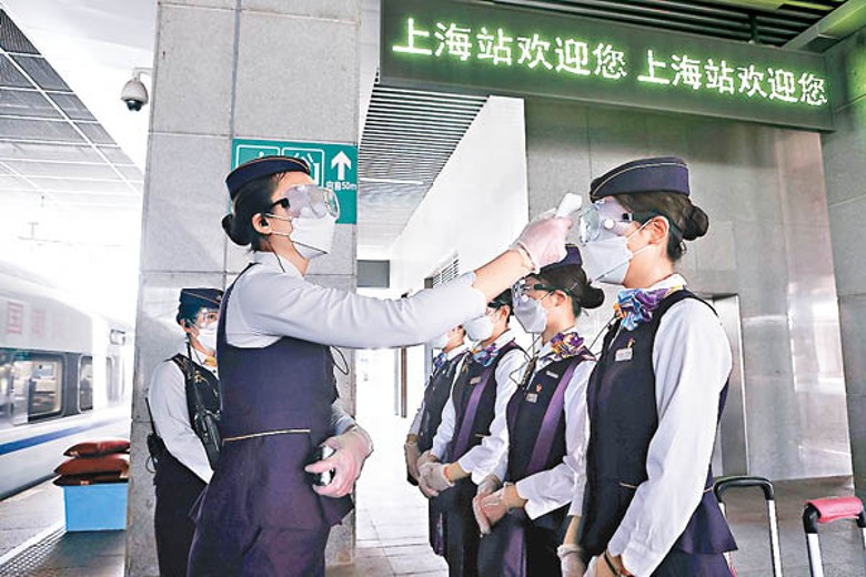 中國鐵路上海局集團列車員檢測體溫。（中新社圖片）