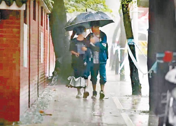廣州有考場工作人員舉傘，護送考生進場。