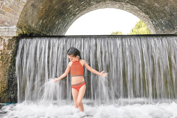英國：倫敦高溫天氣，小女孩玩水消暑。