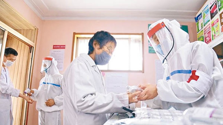 北韓軍方人員協助分發藥物。