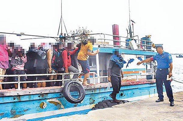 漁船上的偷渡人士被帶回岸上。