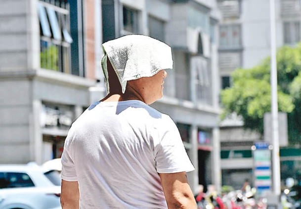 福州酷暑，民眾以毛巾遮擋陽光。