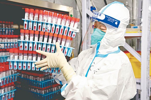 甘肅：蘭州核酸檢測人員搬運樣本。（中新社圖片）