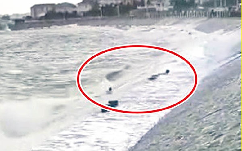 兩名男子（紅圈示）遭巨浪捲走。