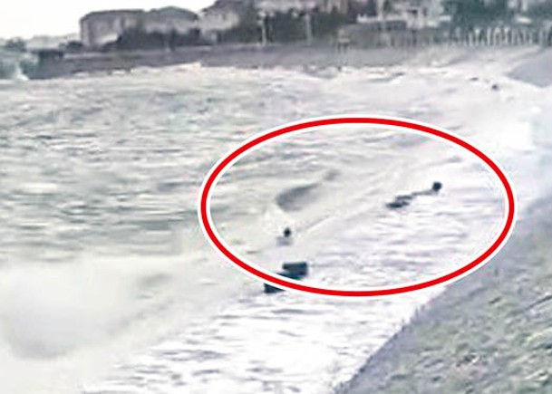 兩名男子（紅圈示）遭巨浪捲走。